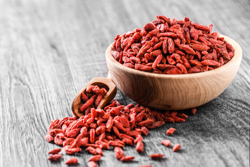 Goji in wooden bowl. Fresh goji fruit for perfect health. Goji on wooden table.