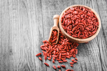 Goji in wooden bowl. Fresh goji fruit for perfect health. Goji on wooden table.