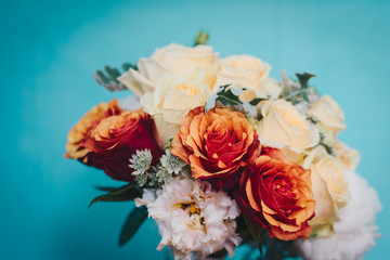 Wedding bouquet made of variety of roses on a blue wall background