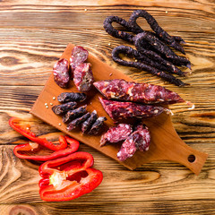 Grilled sausages with vegetables close up on an old table