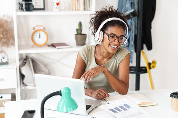 African woman using laptop computer listening music