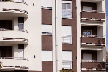 Fragment of a building with balconies and shutters on the window