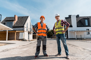 middle aged builders standing with hands on hips outside