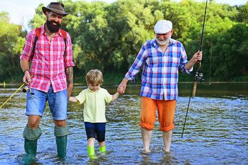 Male multi generation family. Happy grandfather and grandson are fishing on the river. Father, son and grandfather on fishing trip.