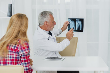 Naklejka na ściany i meble Doctor pointing at x-ray with patient