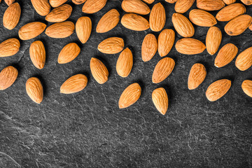 Obraz premium Almonds background. Fresh nice almonds from top view, on dark stone table.