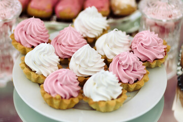 Cakes at the wedding, white plate on the mirror table.
