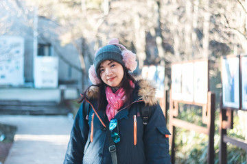 Beautiful young Asian woman in her winter jacket, traveler concept.
