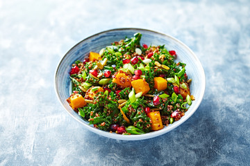 Hokkaido pumpkin and quinoa salad with kale, pomegranate, spring onion and toasted sunflower seeds. Healthy homemade food. Vegan food