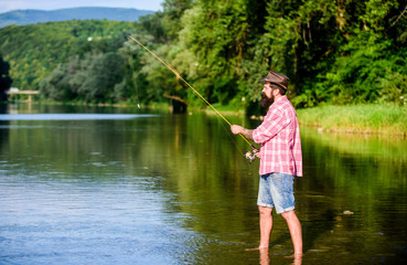 Fototapeta na wymiar big game fishing. relax on nature. mature bearded man with fish on rod. successful fisherman in lake water. hipster fishing with spoon-bait. fly fish hobby. Summer activity. It is a big fish