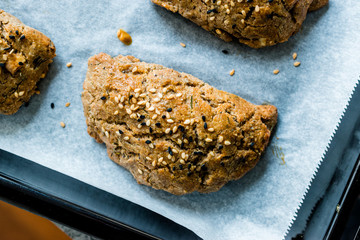 Homemade Turkish Pastries Pogaca made with Karakilcik Wheat, Cheese with Black Cumin Seeds on Baking Paper.