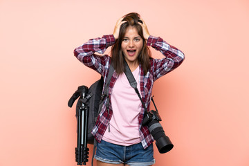 Young photographer girl over isolated pink background with surprise facial expression