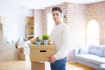 Fototapeta na wymiar Young man smiling holdig cardboard box, happy moving to a new house