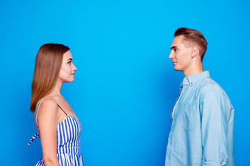 Fototapeta premium Profile side view portrait of her she his he two nice attractive charming lovely content calm people looking at each other trust care isolated over bright vivid shine vibrant blue color background