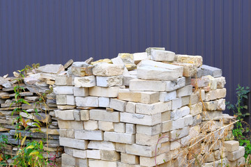 Construction Materials. Building materials for construction of residential house. Pile of brickwork at construction site. Bricks stacked.
