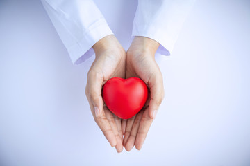 Woman doctor hands holding red heart on white background donate for hospital care concept. world...