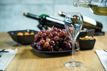 Pouring wine into glass and food background