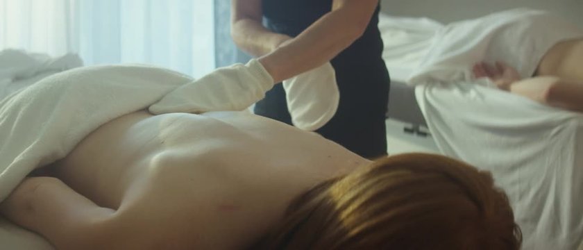 back massage to an unrecognizable woman who is attending a couple massage with her husband - Eine Masseurin gibt einer unerkennbaren Frau eine R&uuml;ckenmassage w&auml;hren einer Paarmassage mit Ihrem Ehemann