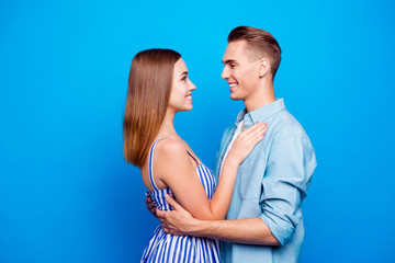 Profile side view portrait of his he her she two nice attractive charming lovely lovable sweet cheerful people embracing isolated over bright vivid shine vibrant blue turquoise color background