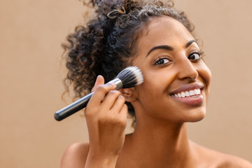 Black beauty woman using makeup brush