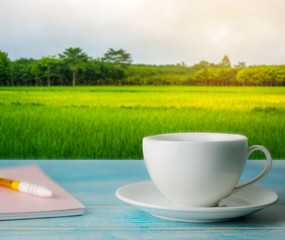 A cup of coffee with rice field rural with colorful of sky in morning light