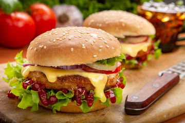 Hamburger with beef meat and fresh vegetables on wooden background