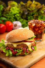 Hamburger with beef meat and fresh vegetables on wooden background