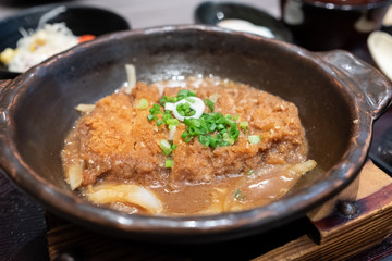 Crispy fried pork or Tonkatsu with miso sauce in the bowl. Japanese food.