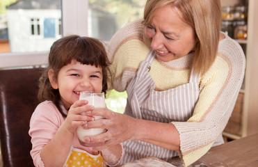 Obraz na płótnie Canvas Cute kid is drinking milk