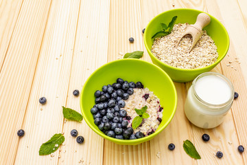 Oatmeal porridge with fresh blueberry, mint leaves and yogurt