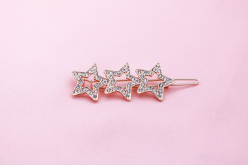 Luxury star shape hair clip on pink fabric with copyspace.
