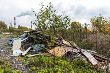 The unauthorized dump of garbage among the wild nature near the industrial and living areas