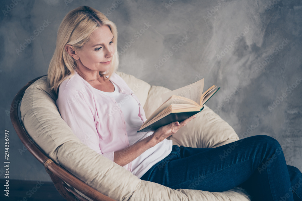 Sticker portrait of focused middle aged woman in pastel color pullover denim jeans read book encyclopedia wa