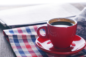 Close up red coffee cup on nepery and background newspaper