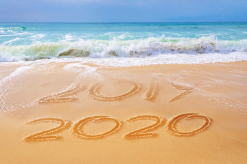 2020 written on the sand of a beach, travel 2020 new year concept and greeting card