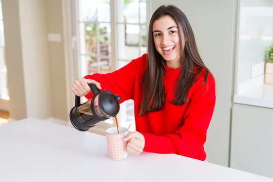 Young beautiful woman making morning coffee smiling, preparing a cup of latte for breakfast