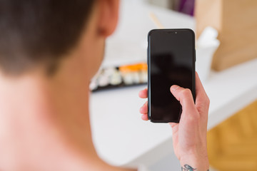 Close upf man using smartphone to orden take away asian food from delivery