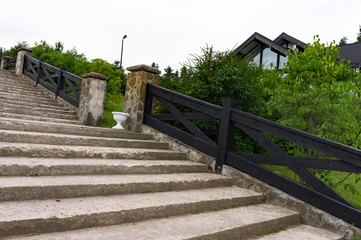 Fototapeta na wymiar Stone desert staircase in a quiet Scandinavian-style village. Steps among the greenery
