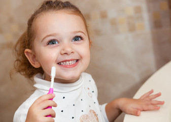 Cute little girl cleaning tooth with brush.