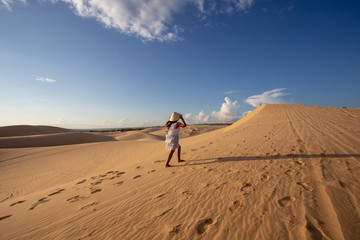 Fototapeta na wymiar Portrait Young Asian Woman travel, On White Sand dune desert Muine, in Vietnam