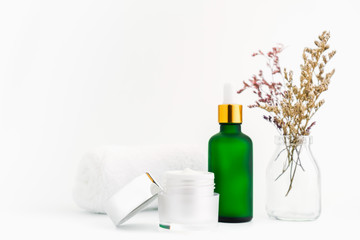 White serum bottle and cream jar, mockup of beauty product brand. Top view on the white background.