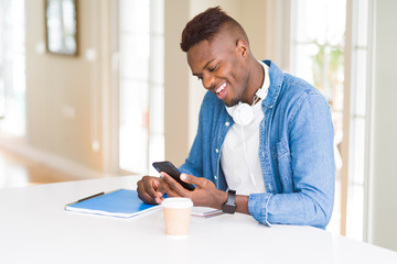 Handsome young african business man using smartphone smiling confident