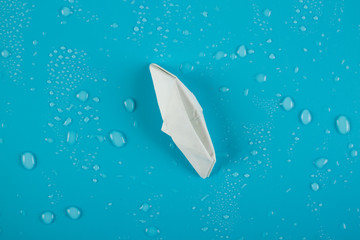 Paper boat is sinking into the sea.