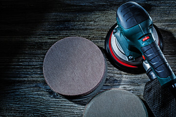 electric hand tool wood finishing detail sander with sanding discs on vintage wooden background