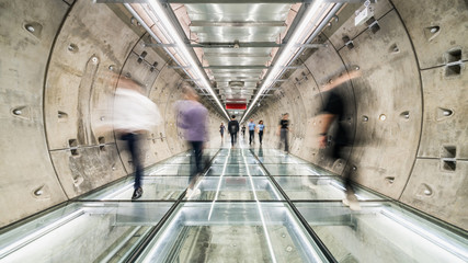 Motion blur of unidentified Asian people walking in subway tunnel walkway. Underground public...