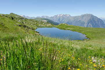 Un lac de montagne en été. Un lac à Vaujany. Un lac des Alpes pendant l'été. Une prairie des Alpes en été.