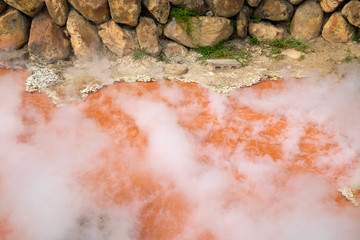 The steam rises up from the red hot spring. in Umi Jigoku of Beppu, Oita-shi, Kyushu, Japan.
