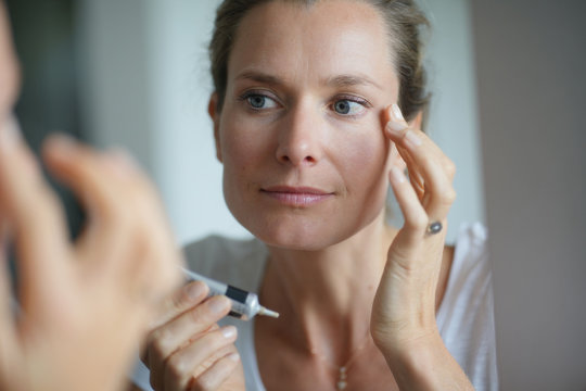 Portrait Of Woman Applying Eye Concealer