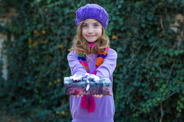 Little cute child giving a gift. Selective focus on box with gift.