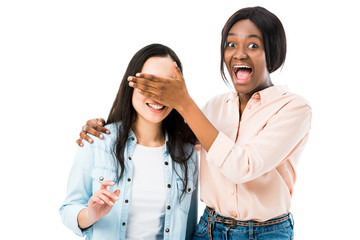 smiling african american woman obscuring face of her friend isolated on white